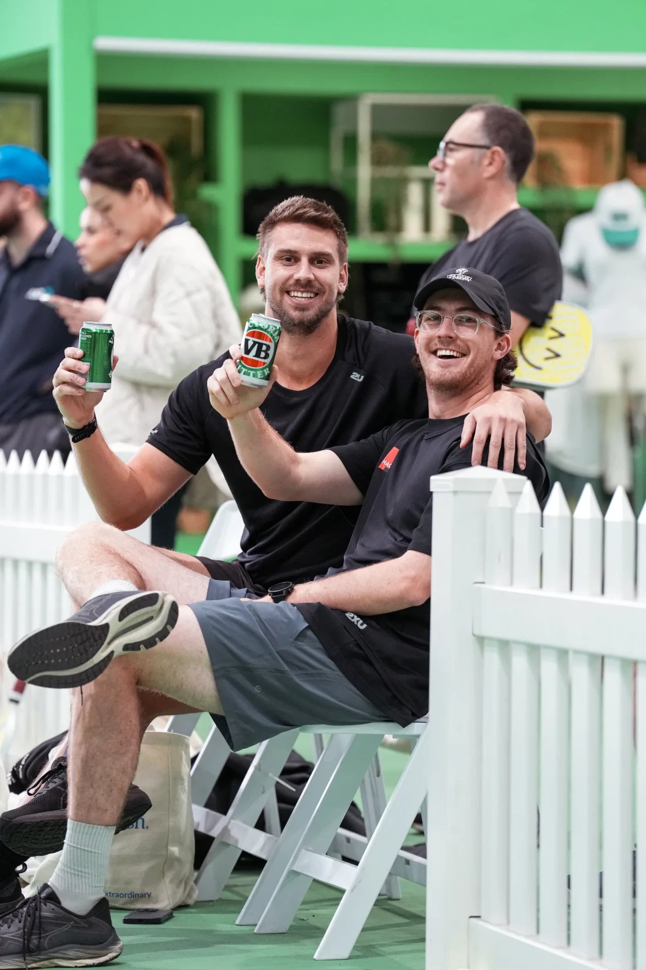 Two members relaxing courtside with drinks at The Jar South Melbourne