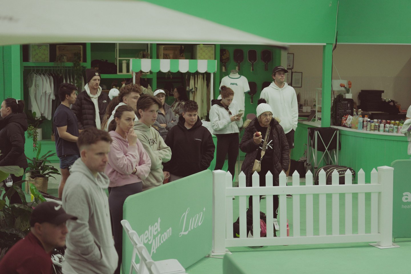 The Jar, South Melbourne — courtside pro shop and bar with players watching a match