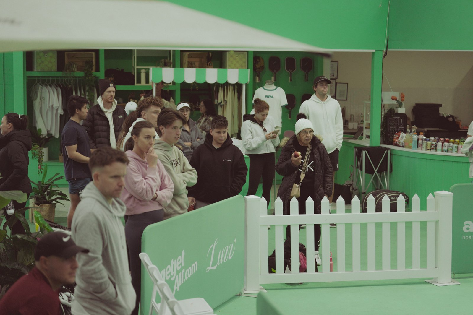 The Jar, South Melbourne — courtside pro shop and bar with players watching a match