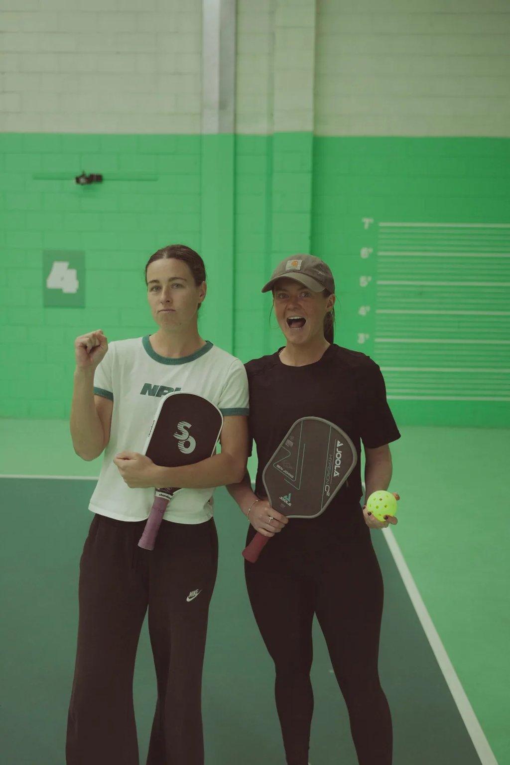 Two players holding paddles and pickleballs during a coaching clinic at The Jar South Melbourne